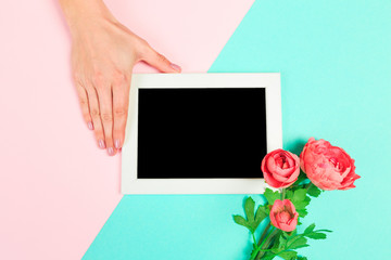 Beautiful young woman's hands holding frame for your text place  on pastel  background .