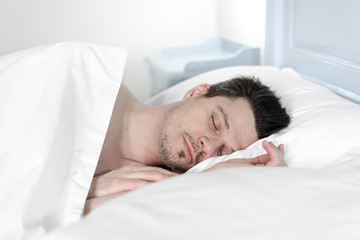 Fototapeta na wymiar young man sleeping in bed