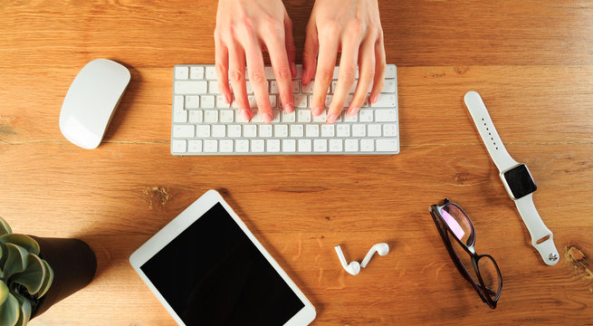 Female hands working with modern white keyboard and mouse on wooden background, top view  - Image - Powered by Adobe