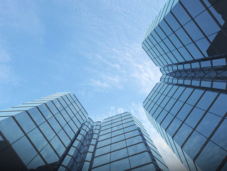 Obraz premium View of glass building on blue sky background,Business concept of future architecture,looking up to the light on the top of building. 3d rendering.