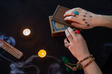 Fortune teller using tarot cards on black background