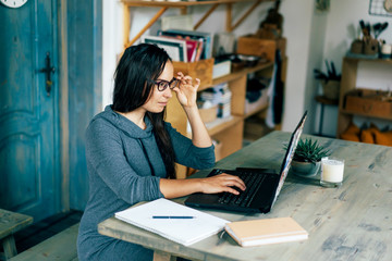 Smart business successful bossy woman at the table reads in a laptop. Work from home. E-commerce and e-business. Remote work and study. Quarantine and self-isolation