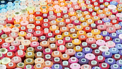 many bobbins of thread of different colors background