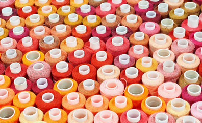 many bobbins of thread of different colors background