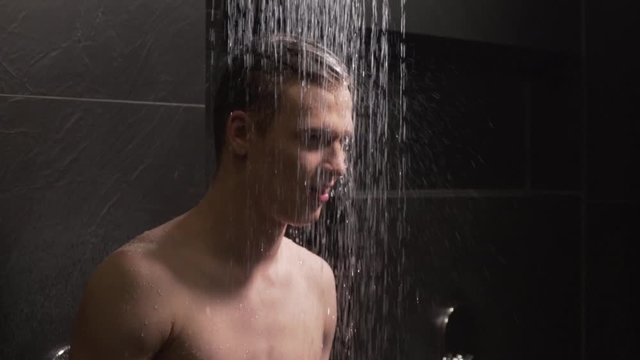 handsome guy washes in the shower