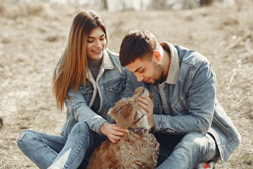 Woman in a jeans clothes. Couple in a spring forest. People with a cute dog.