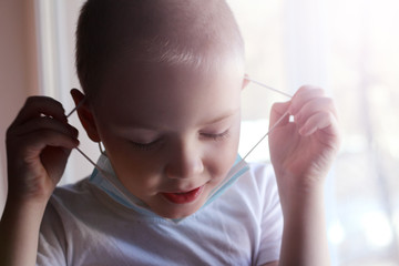 A little boy takes a medical mask, coronavirus