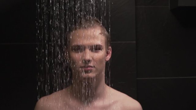 handsome guy washes in the shower