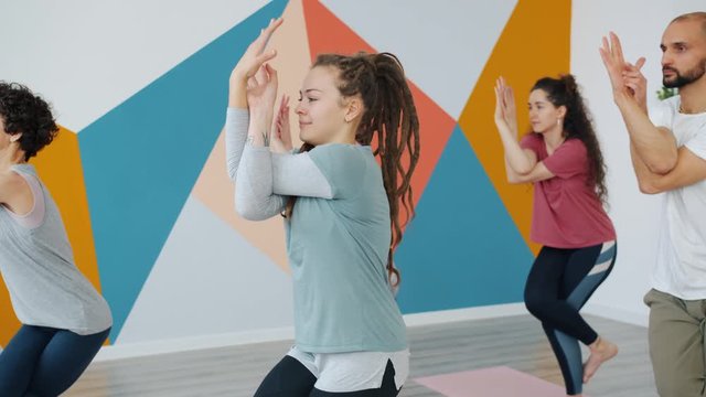 Group of yoga students is doing Garudasana asana in studio enjoying practice together concentrated on physical exercise. People and well-being concept.