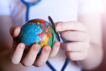 Stethoscope and globe in children's hands