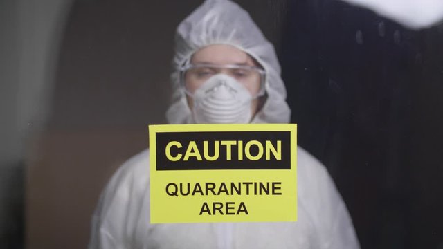 woman in protective suit in quarantine zone. Coronovirus and isolation concept