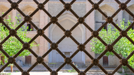 Fototapeta premium View from behind bars at Modarikhan Madrasah (uzbek 