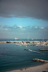 Panoramic view of white luxury yachts and sailing boats moored in harbor of Santa Margherita Ligure, Italian Riviera. Beautiful mediterranean landscape with cloudy blue sky.