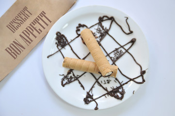 Wafer roll with condened milk. Coffee desserts. Delicious dessert with coffee.