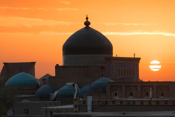Sunrise view at Itchan Kala (old or inner town) and Pakhlavan Makhmud Mausoleum (tomb), one of the most popular touristic attraction in the city. Khiva, Uzbekistan, Central Asia.