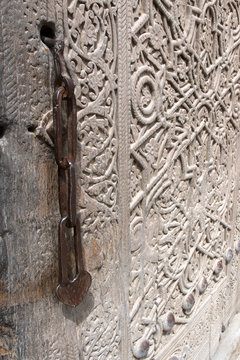 Old wooden door (with chain lock) of zindan (prison) in Kuhna Ark fortress. Khiva, Uzbekistan.