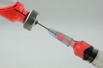 Health worker prepares a Syringe with Red liquid