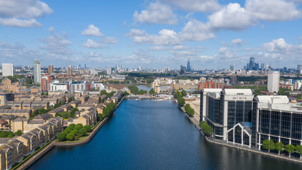 Obraz premium River Thames and water canal surrounded by residential buildings in London Docklands area near Canary Wharf