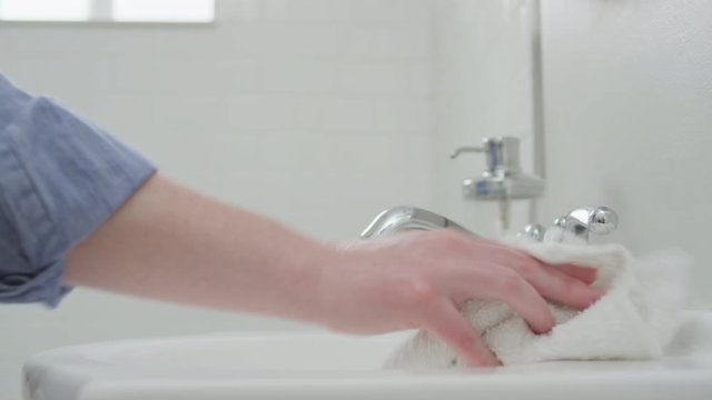 Woman Uses Disinfecting Spray To Sanitize Her Bathroom Sink With Fresh Rag