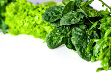 Green vegetables. Green fruits and vegetables on a white background. Apples, parsley, spinach, arugula and lettuce on a white background. Top view. Spinach and vegetable smoothies with copy space