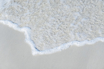 Ocean waves on the sandy beach for background, concept of the beach in the summer