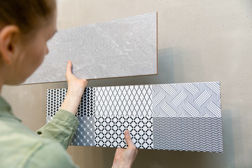 woman choosing wall tiles for her new bathroom interior design