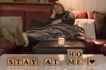Infection risk with Corona Virus. Stay at home. A woman stays in the living room. She cuddles up in...