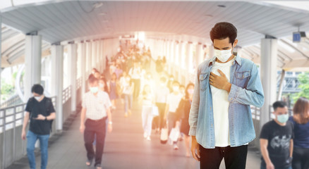 Fototapeta premium Asian young man wearing protective surgical face mask, cough and hurt at chest, air pollution from PM2.5 and coronavirus,covid-19 virus pandemic,air pollution concept