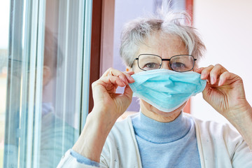 Senior in quarantine as a Covid-19 patient with a face mask