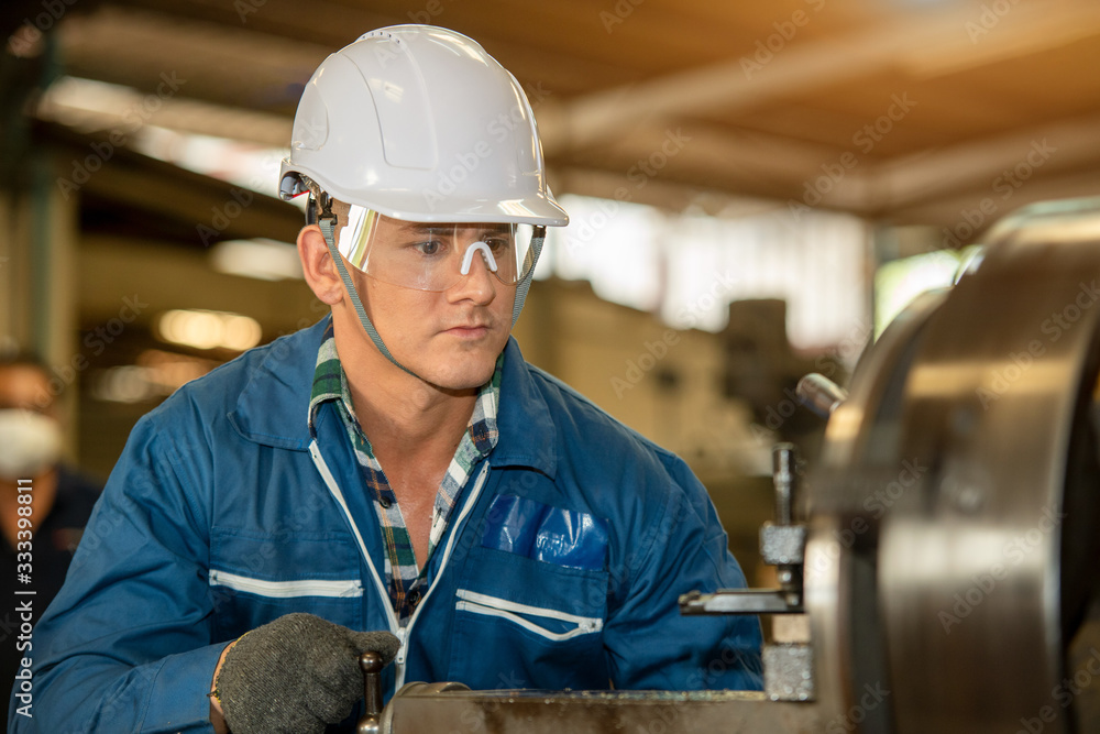 Poster Technician working on lathe spare part machine in iron manufacturing factory,Works in a lathe concept.