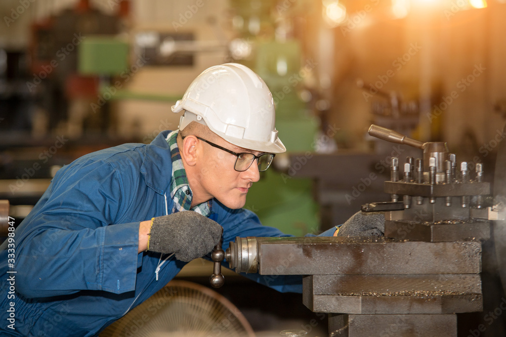 Poster factory worker,engineer wearing uniform safety in factory working machine lathe metal.