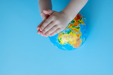 Children's hands pray,for planet Earth.
Concept of global problems of humanity.