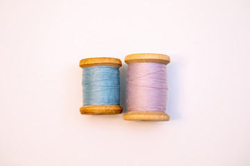 Two spools of thread on a white background