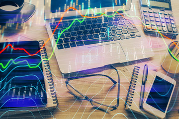 Double exposure of chart and financial info and work space with computer background. Concept of...