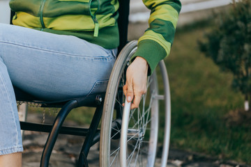 Close up of a young woman in a wheelchair while walking in a park on a sunny day. Recovery and...