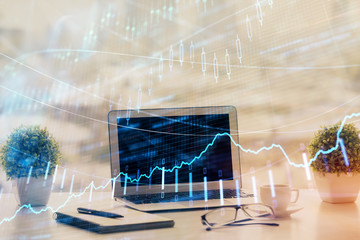 Stock market graph on background with desk and personal computer. Double exposure. Concept of financial analysis.