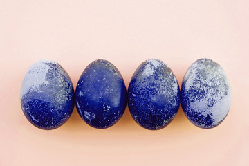 Natural dyed blue colored eggs on pastel beige background.