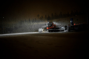 Snowcat preparing a slope at night