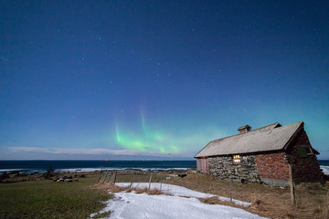 ULSTEIN, NORWAY - 2016 FEBRUARY 19. Northern light and a old farm house at Flo.