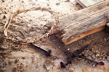 Easter background depicting the crucifixion with a rustic wooden cross, crown of thorns and nails.