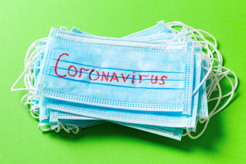 Top view of protective medical masks on green background. Coronavirus word. Ncov and covid...