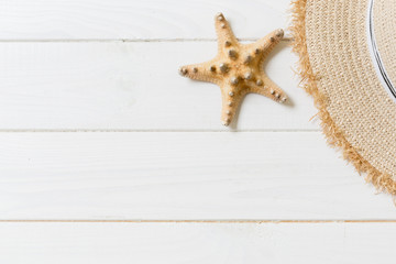 Fototapeta na wymiar Straw hat and starfish On a white wooden background. top view summer holiday concept with copy space