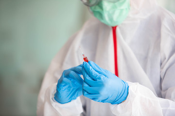 Fototapeta premium Doctors are searching for Covid's anti-virus serum by studying lung infection photos, protected by a mask and sanitary gloves.