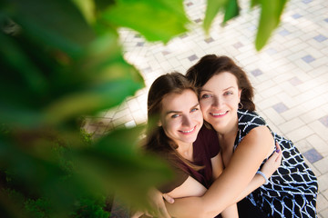 close up portrait of mother and daughter hugging on a bench in the park