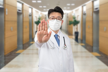 A middle-aged Asian doctor raises his hand and expresses his disapproval.