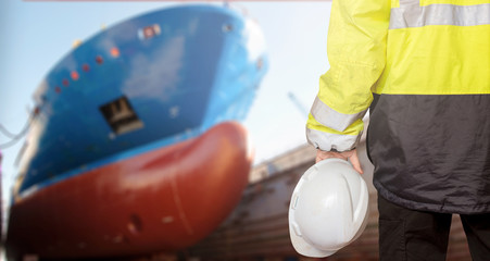 Ship sub-designer or shipbuilder in drydock with ships bow on a background. Ship design, ship...