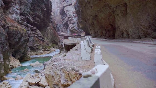 The car drives along the serpentine road in the mountains