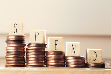 Wooden cubes with the word Spend pile of money coins, money climbing stairs, business concept