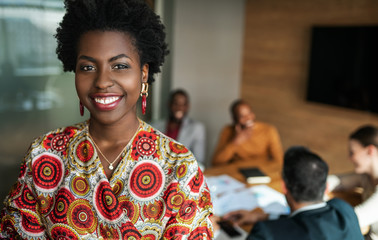 close up of beautiful young smiling professional black african business woman, coworkers hold a...