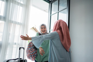 muslim hijab woman happily returns home opens the door and meets her sister